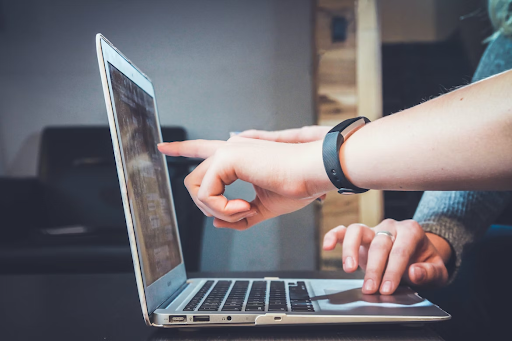 Two hands pointing at a screen. The hands are positioned in front of a screen, with fingers extended and pointing towards specific areas or elements on the display. The hands belong to individuals, and their gender or appearance is not specified in the alt text. The screen itself is not described in detail, but it can be inferred that there is content or information visible that is being referred to or discussed by the hands' gestures.